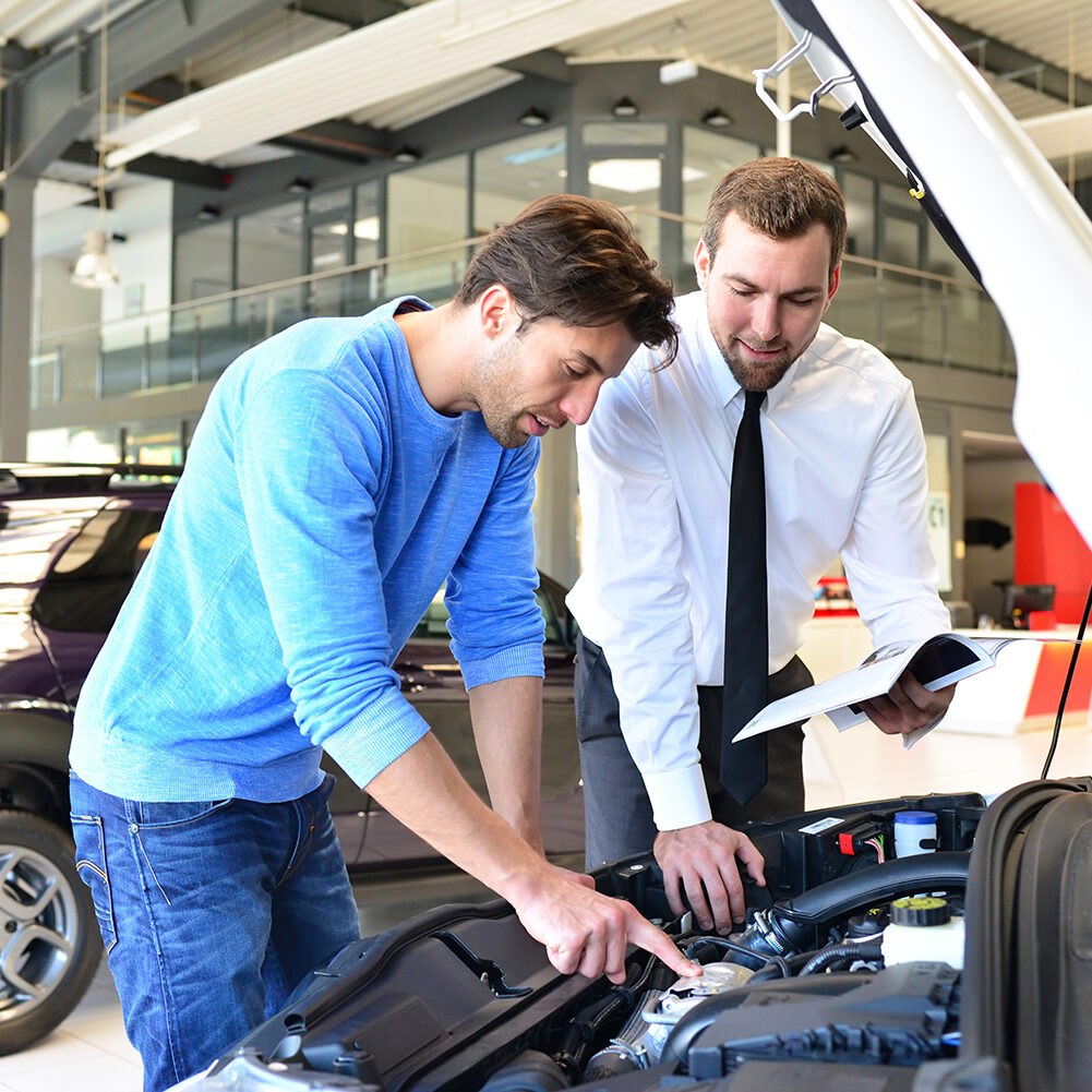 Beratungsgespräch im Autohaus zwischen Kunde und Verkäufer //
